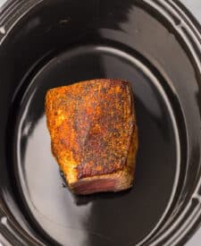 Eye of round roast placed into a slow cooker.