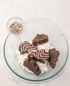 Chocolate Christmas Tree Cake pieces, cream cheese, and whipped topping in a mixing bowl ready to be blended into a creamy holiday dessert dip