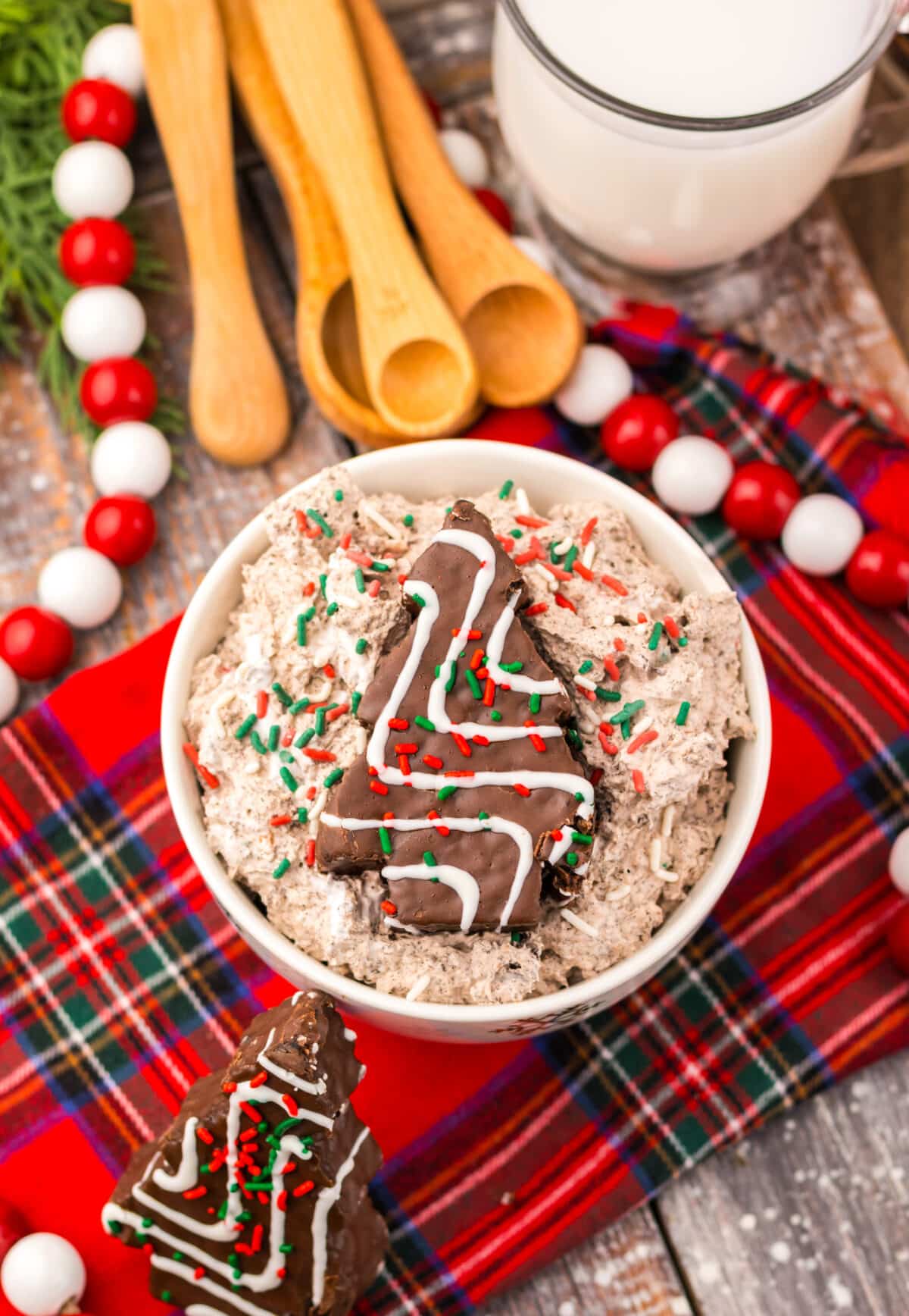 Overhead shot of Chocolate Christmas Tree Cake Dip surrounded by Christmas treats and sprinkles