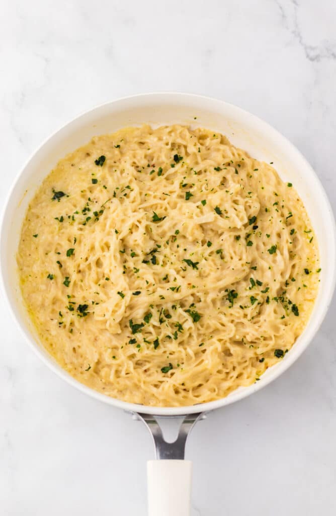 Close-up of garlic parmesan ramen showing creamy noodles and herbs.