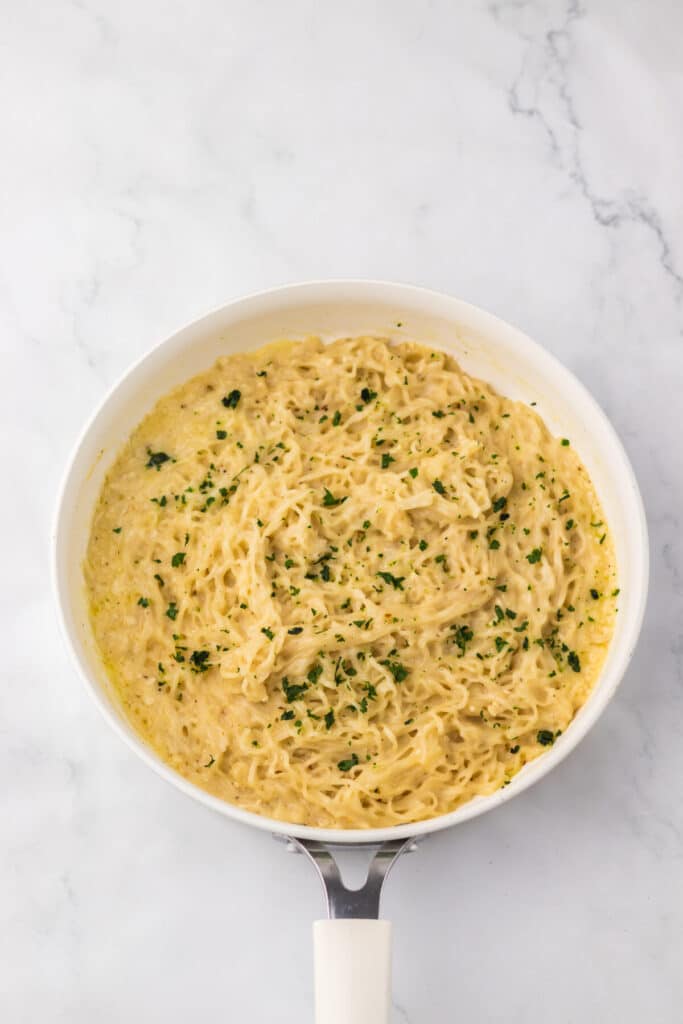 Close-up of garlic parmesan ramen showing creamy noodles and herbs.