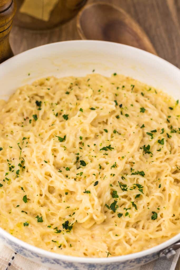 Close-up of garlic parmesan ramen showing creamy noodles and herbs.