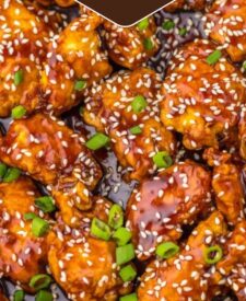 Crispy honey sesame chicken topped with sesame seeds and green onions served over rice.