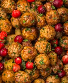Slow Cooker Cranberry Pineapple Meatballs in the slow cooker surrounded by chunks of pineapple and whole cranberries.