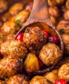 Close-up of Slow Cooker Cranberry Pineapple Meatballs glistening in rich cranberry glaze with pineapple chunks