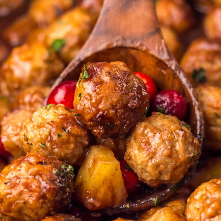 Close-up of Slow Cooker Cranberry Pineapple Meatballs glistening in rich cranberry glaze with pineapple chunks