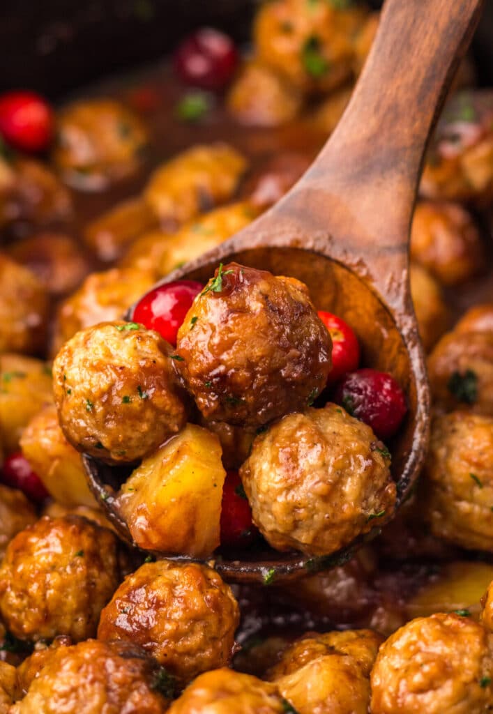 Close-up of Slow Cooker Cranberry Pineapple Meatballs glistening in rich cranberry glaze with pineapple chunks