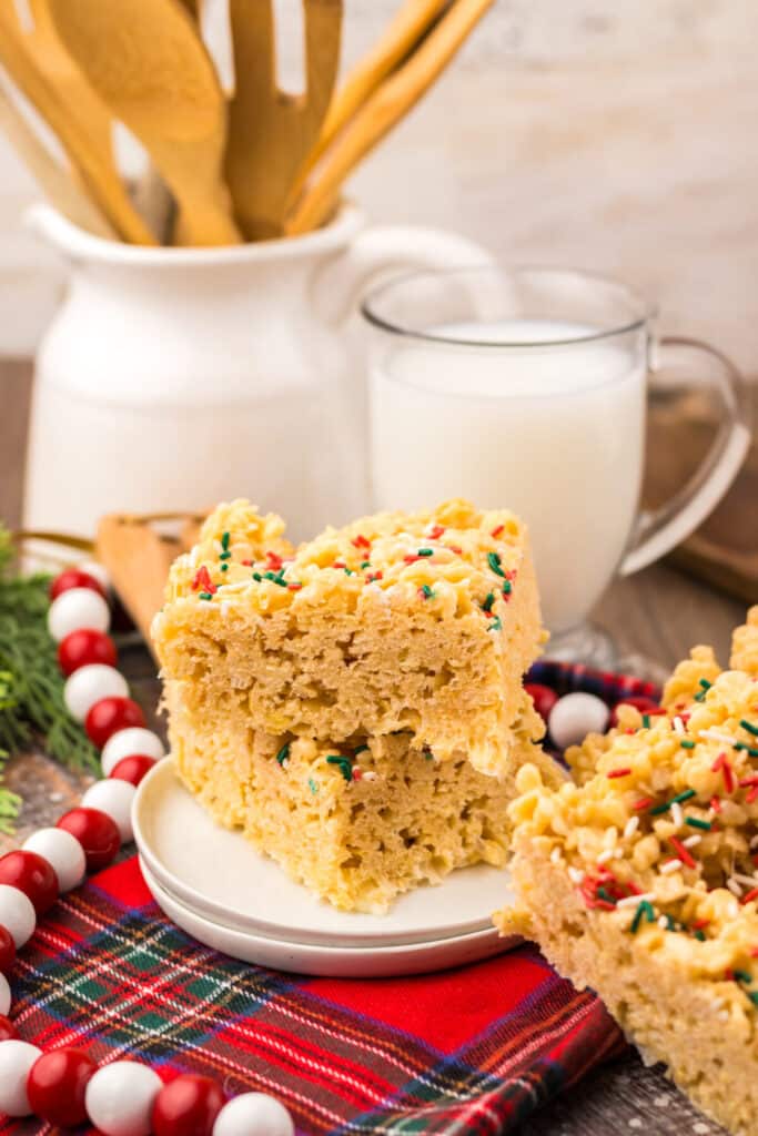 Close-up of Sugar Cookie Rice Krispie Treats topped with festive red and green Christmas sprinkles on a white plate