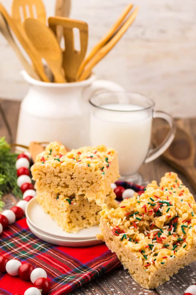Close-up of Sugar Cookie Rice Krispie Treats topped with festive red and green Christmas sprinkles on a white plate