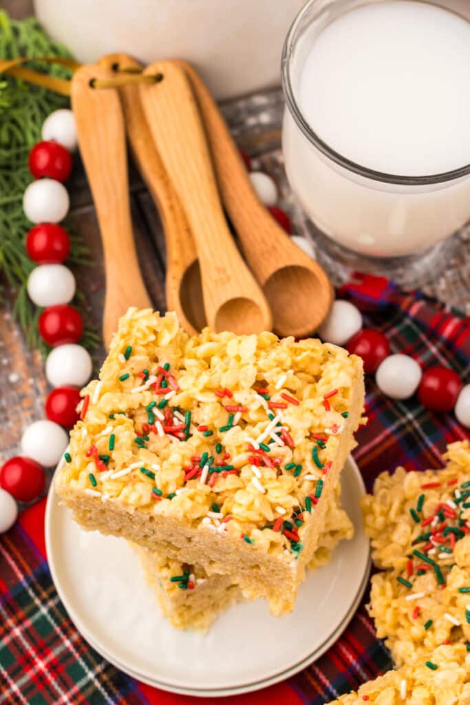 Close-up of Sugar Cookie Rice Krispie Treats topped with festive red and green Christmas sprinkles on a white plate