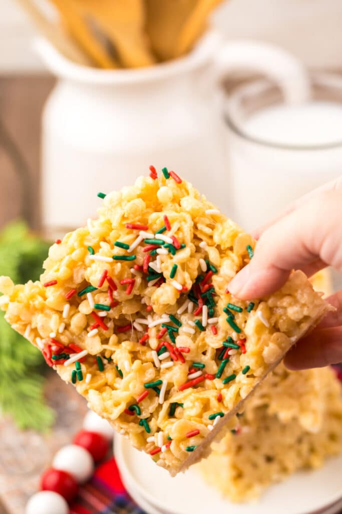 Festive Sugar Cookie Rice Krispie Treats cut into squares, sprinkled with red and green sugar crystals