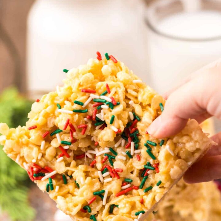 Festive Sugar Cookie Rice Krispie Treats cut into squares, sprinkled with red and green sugar crystals