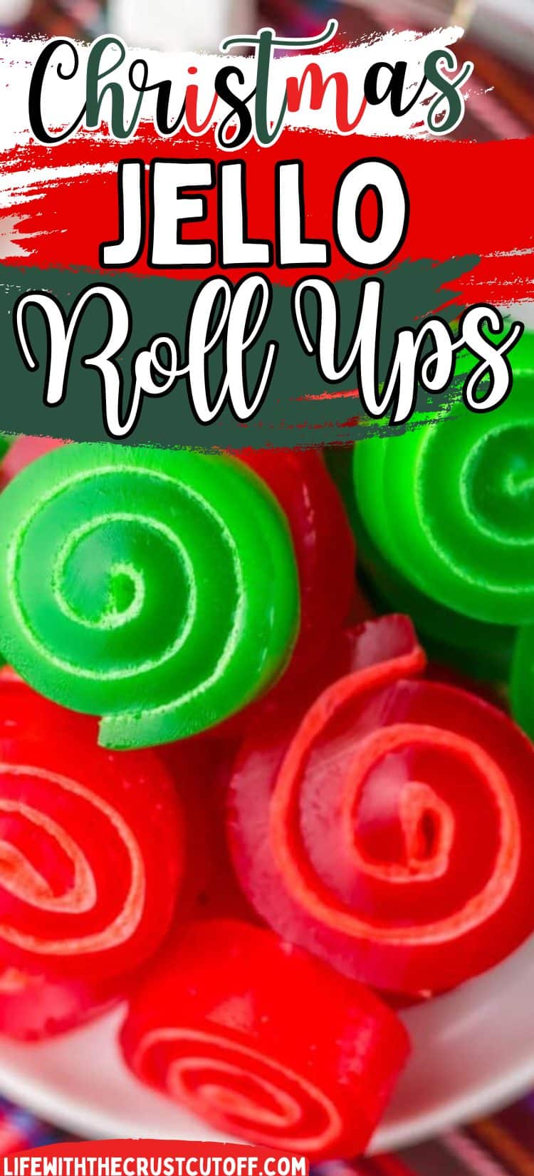 Red and green layered jello marshmallow roll ups sliced on a festive holiday plate