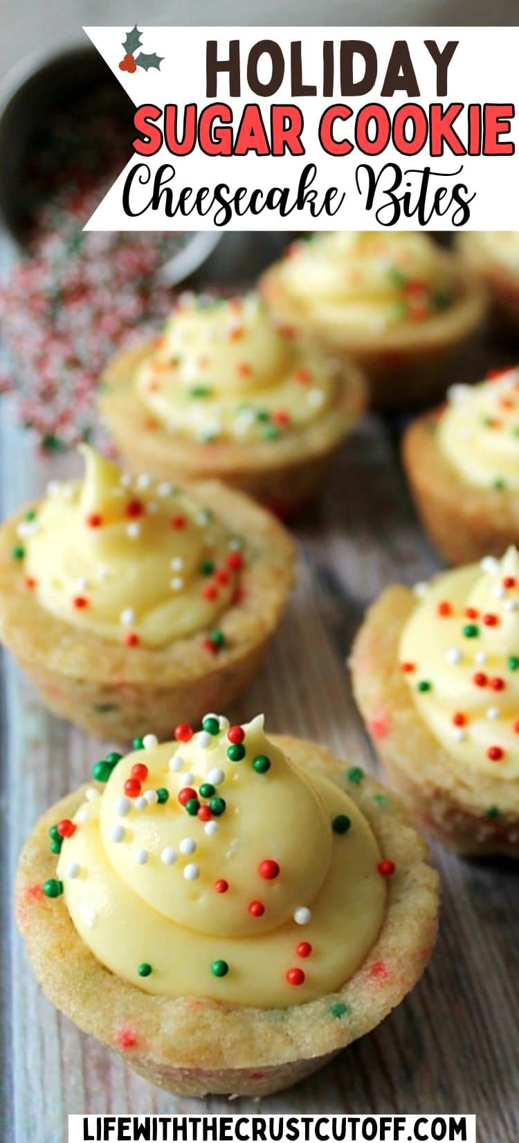 Mini sugar cookie cups filled with creamy cheesecake filling and decorated with red and green Christmas sprinkles on parchment paper