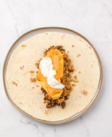 Flour tortilla spread with sauce for copycat quesarito