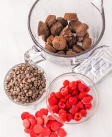 Brownie pieces, cream cheese, and raspberries ready to be mixed for raspberry brownie bombs.