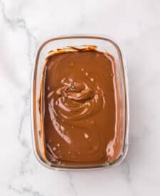 Melted chocolate prepared for dipping raspberry brownie bombs.