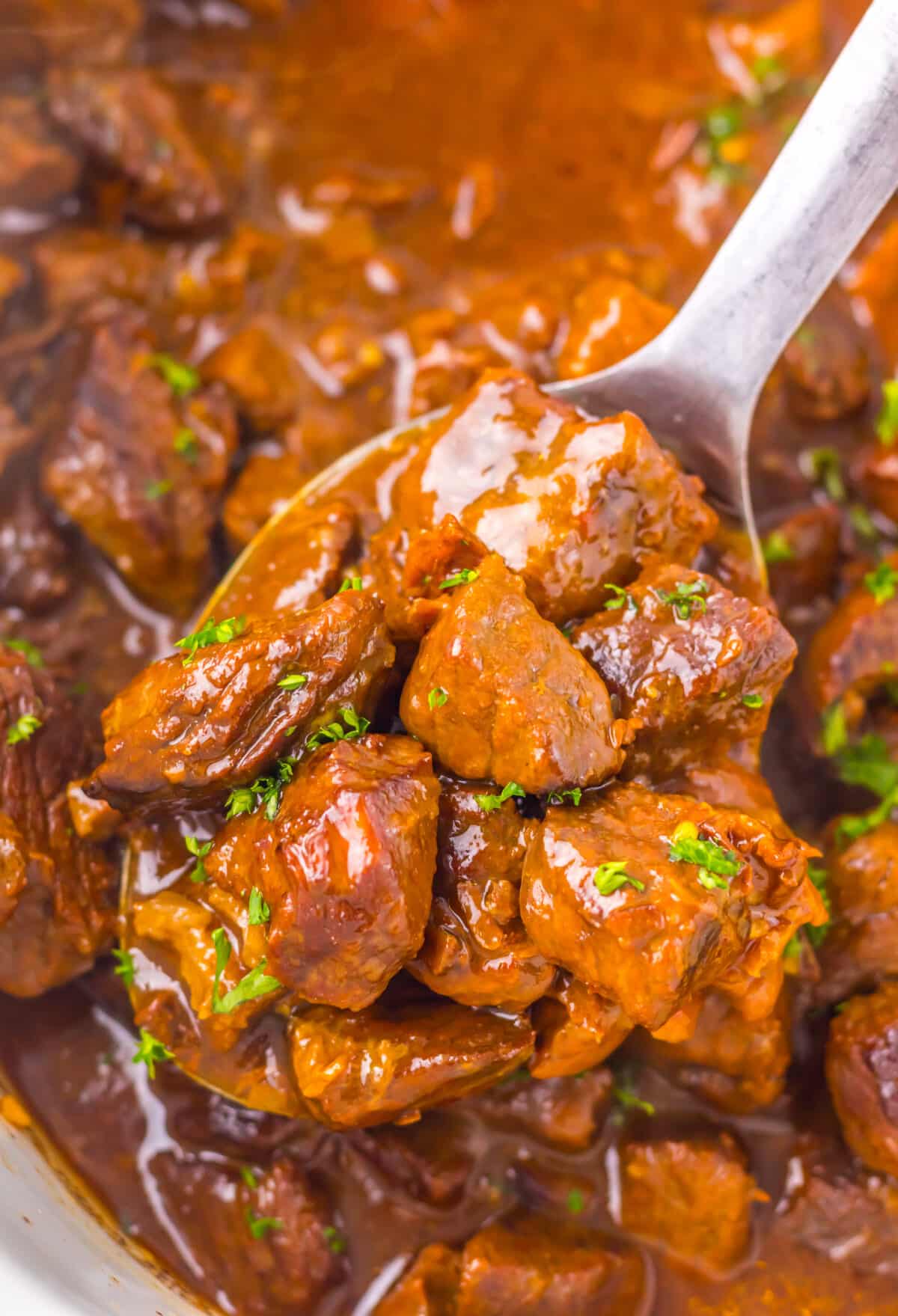 Tender Dr Pepper steak bites coated in a glossy sauce inside the slow cooker.