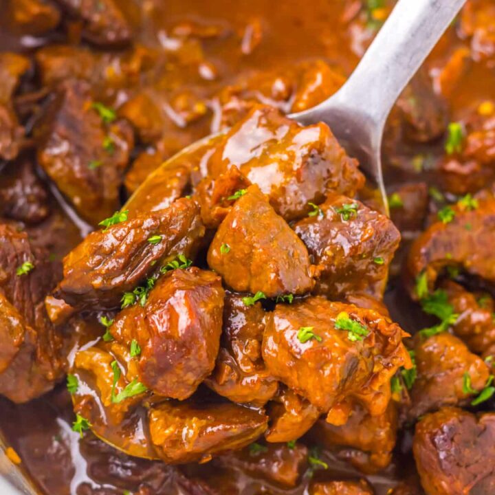 Tender Dr Pepper steak bites coated in a glossy sauce inside the slow cooker.