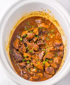 Slow cooker Dr Pepper steak bites cooking low and slow in a flavorful sauce.