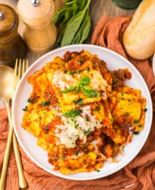 Bowl of slow cooker ravioli lasagna with layers of pasta, meat sauce, and cheese