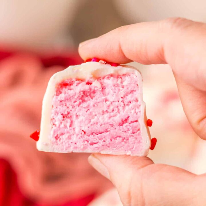 Cross-section view of strawberry Cool Whip candy showing pink filling and white chocolate layer.