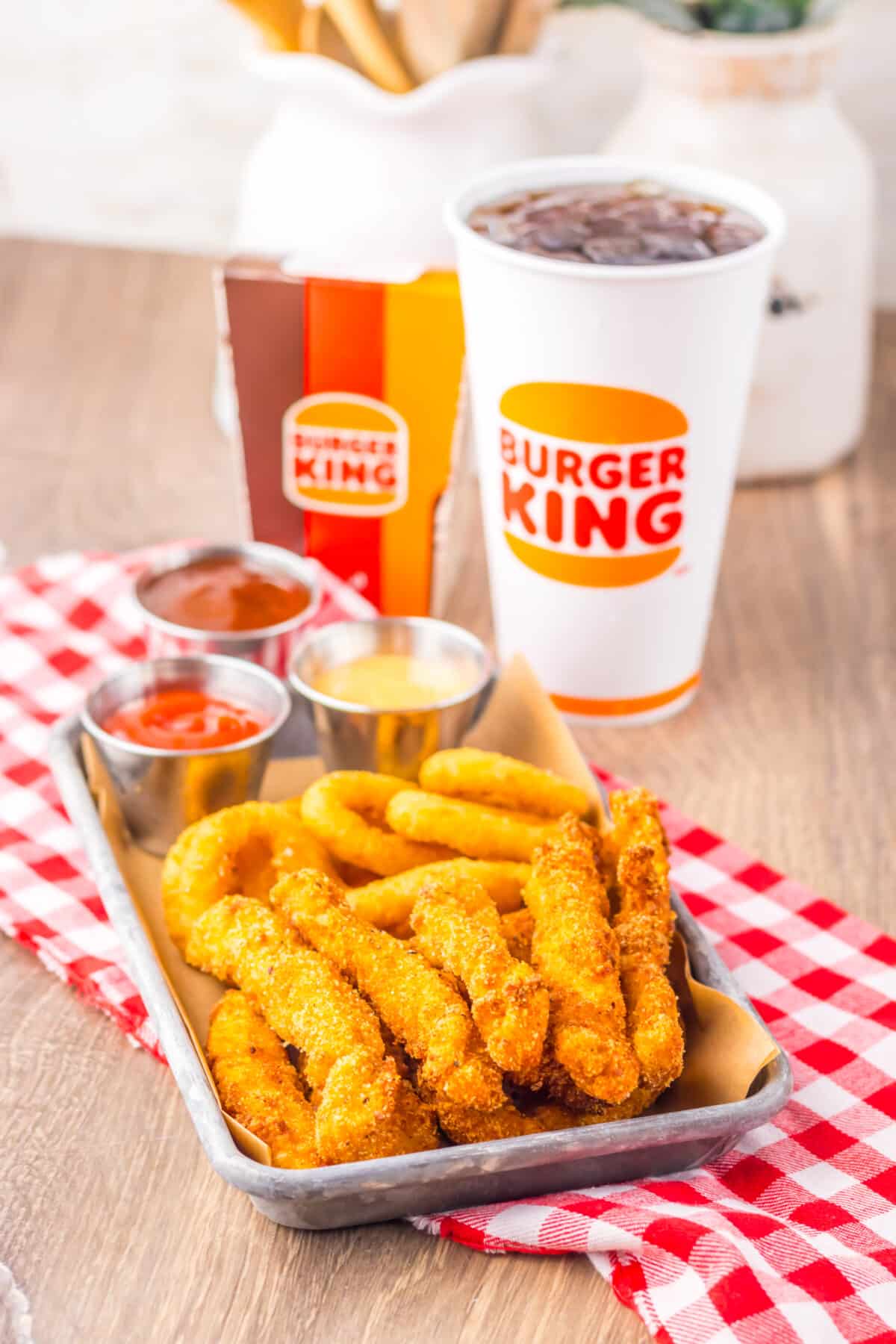 Close-up of golden fried chicken fries with dipping sauce.