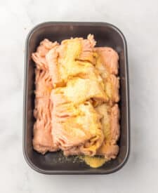 Chicken patties layered in a baking dish before cooking.