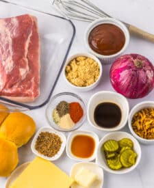 Ingredients for slow cooker brisket sliders including brisket, seasonings, and sauce.