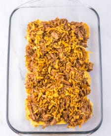 Close-up of brisket slider showing tender beef and sauce on a golden bun ready to bake.