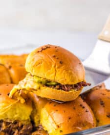 Close-up of brisket slider showing tender beef and sauce on a golden bun.