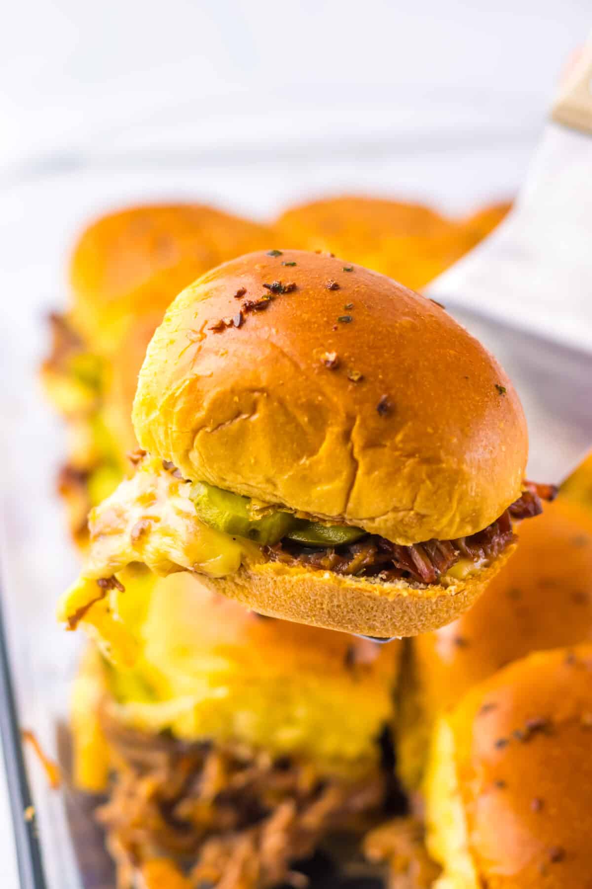 Close-up of brisket slider showing tender beef and sauce on a golden bun.