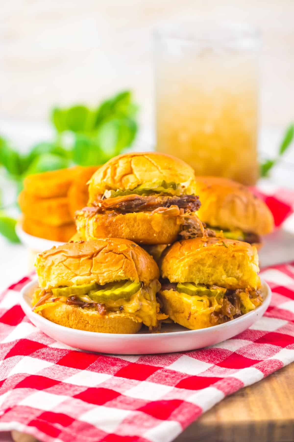 Slow cooker brisket sliders stacked together on a serving platter.