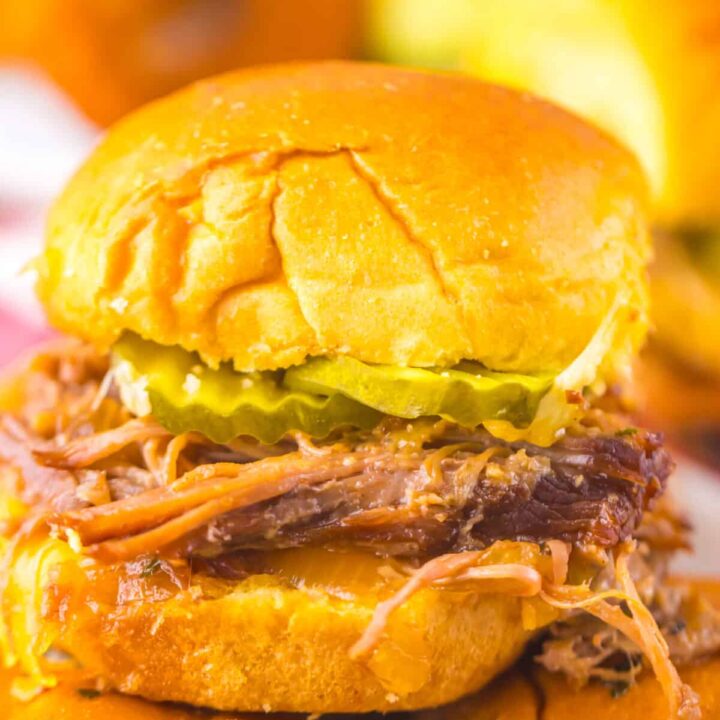Slow cooker brisket slider served on a soft bun with tender shredded beef.