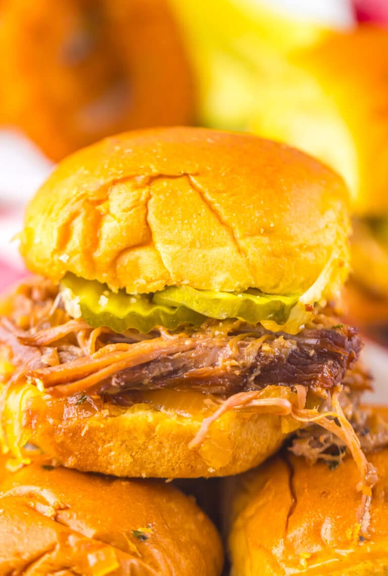 Slow cooker brisket slider served on a soft bun with tender shredded beef.
