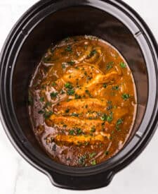 Slow cooker Dr Pepper pork chops simmering in a sweet and savory sauce.