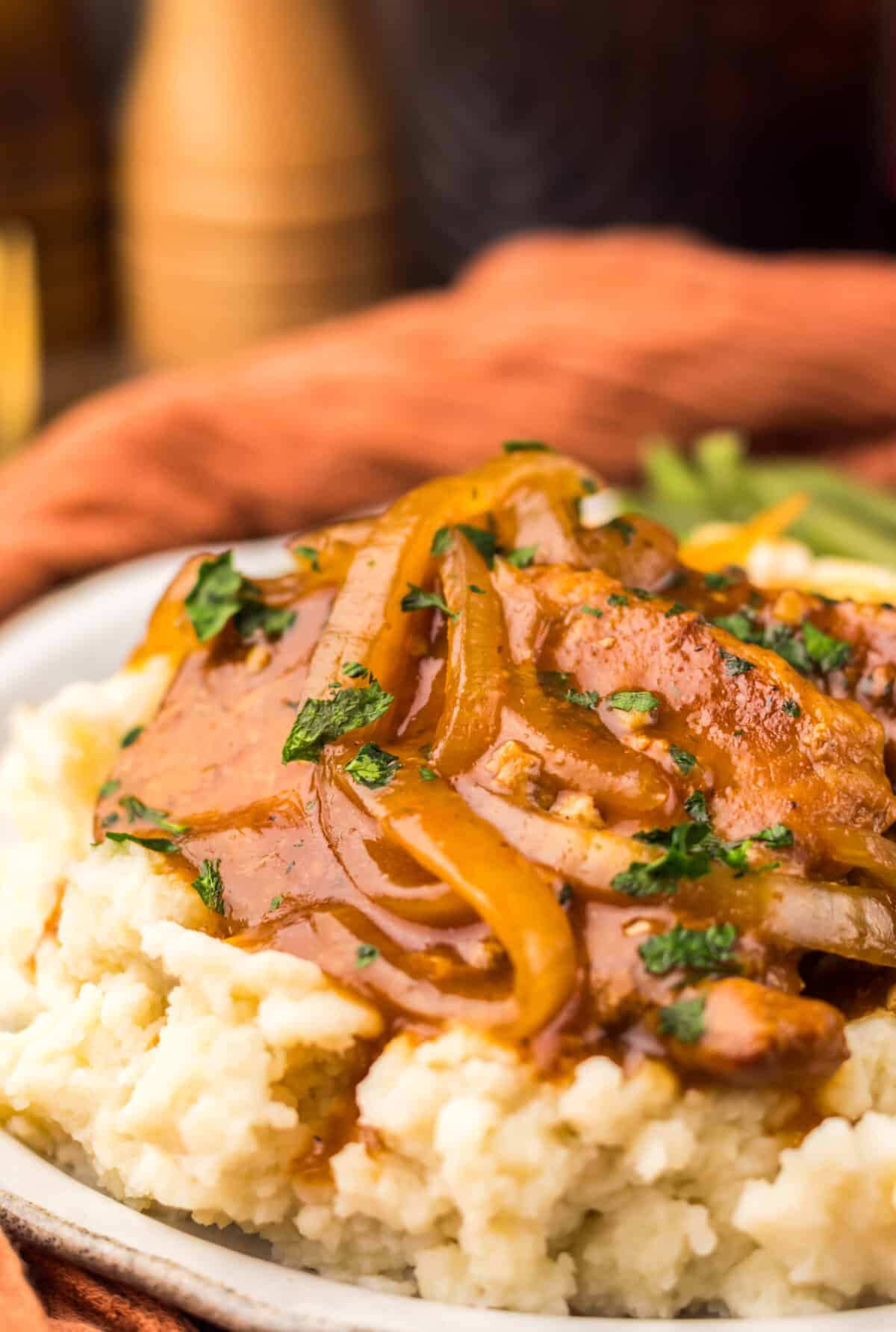 Finished Dr Pepper pork chops served over mashed potatoes.