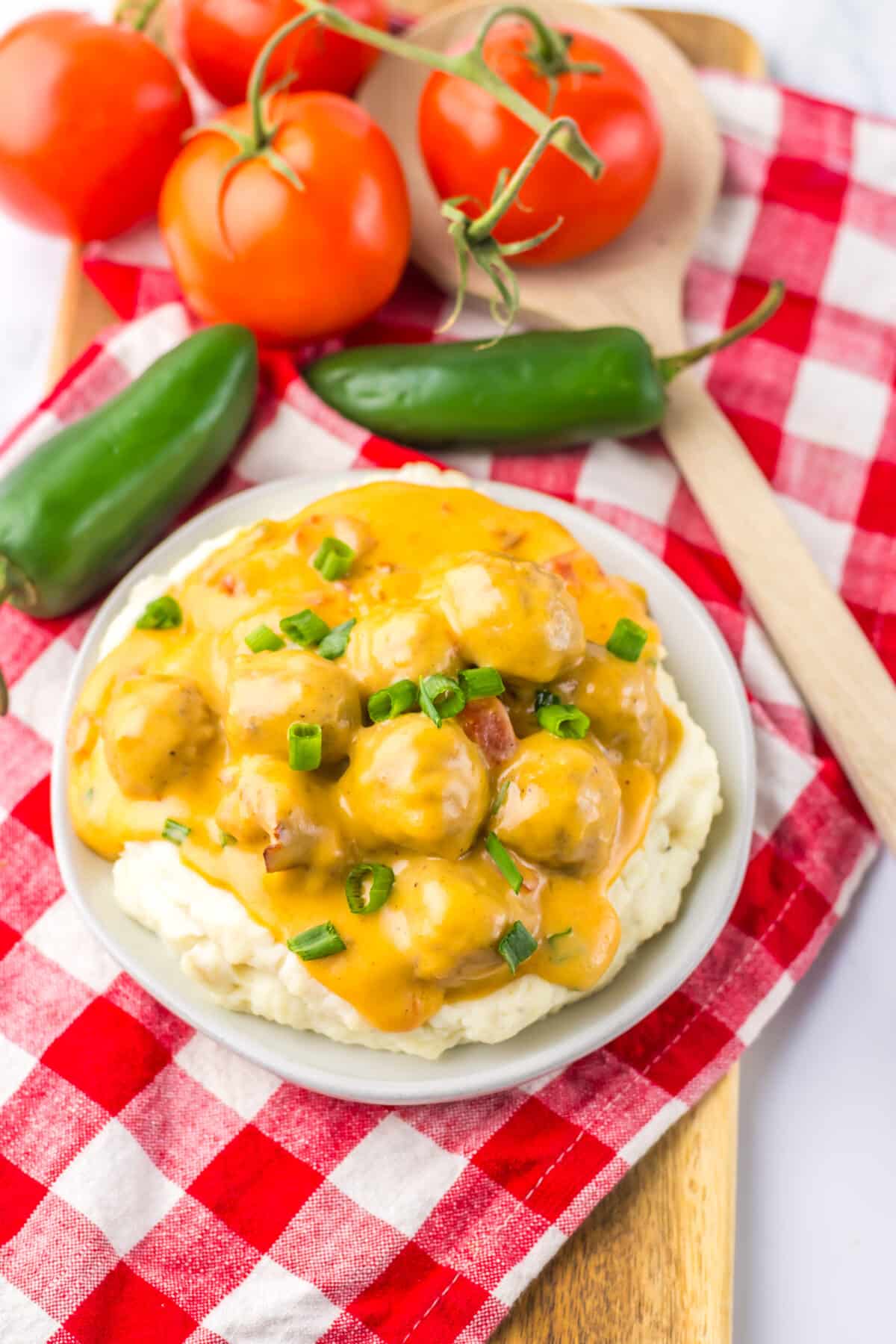 Nacho meatballs served as an appetizer on a red checkered napkin.