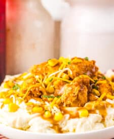Popcorn chicken layered over mashed potatoes and corn.