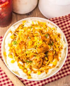 Copycat KFC Famous Bowl served with mashed potatoes, popcorn chicken, corn, gravy, and shredded cheese.