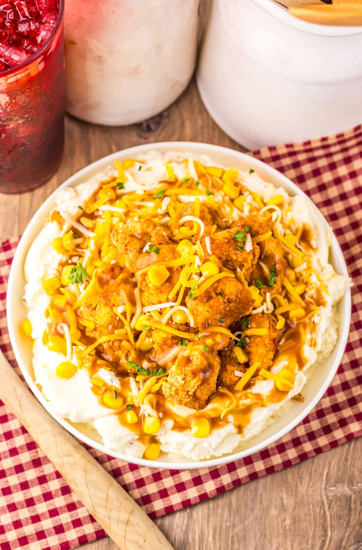 Copycat KFC Famous Bowl served with mashed potatoes, popcorn chicken, corn, gravy, and shredded cheese.