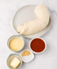 Ingredients for copycat Little Caesar’s Crazy Bread including pizza dough and seasonings.
