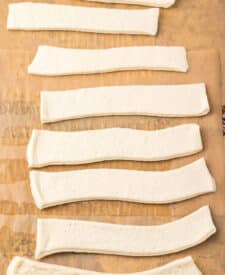 Pizza dough cut into strips for homemade Crazy Bread.