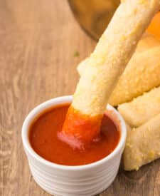 Crazy Bread stick dipped into marinara sauce.