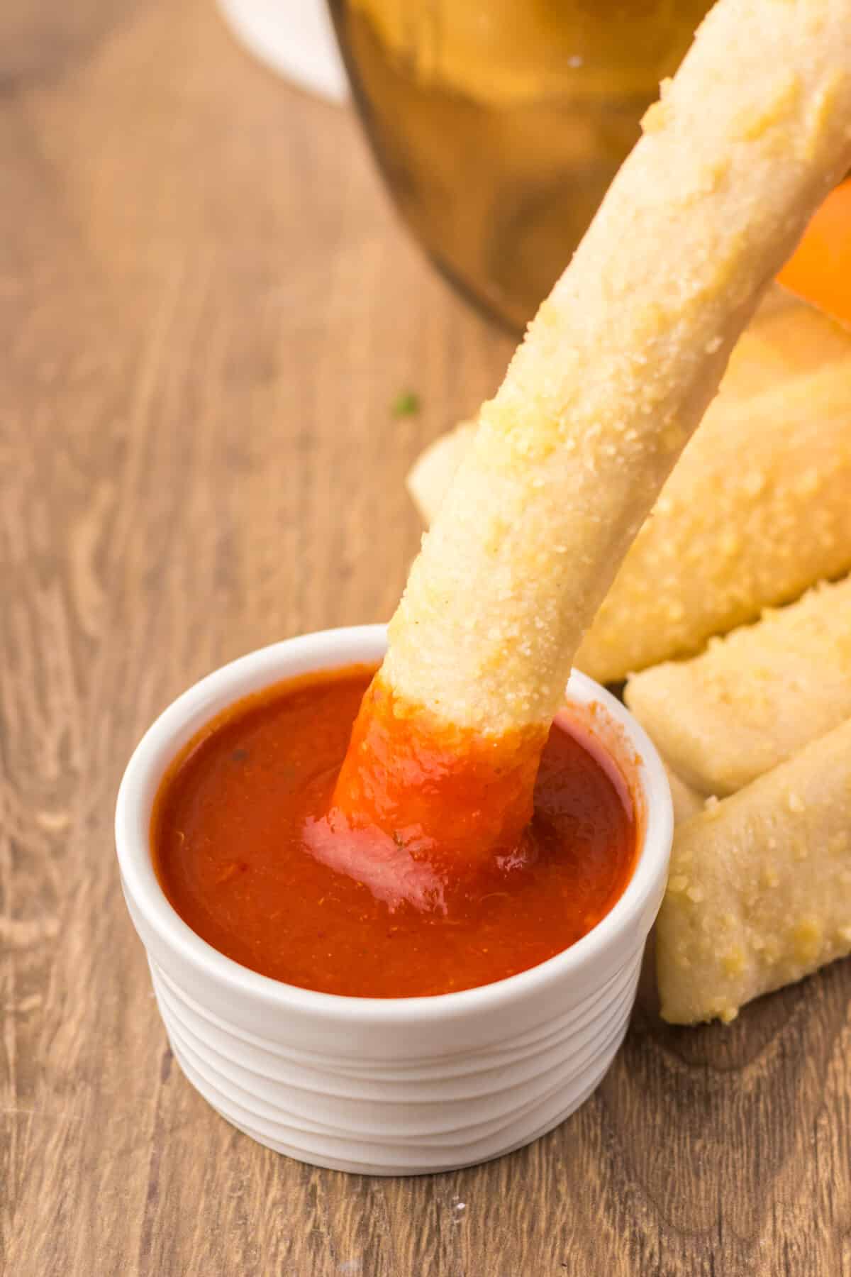 Crazy Bread stick dipped into marinara sauce.