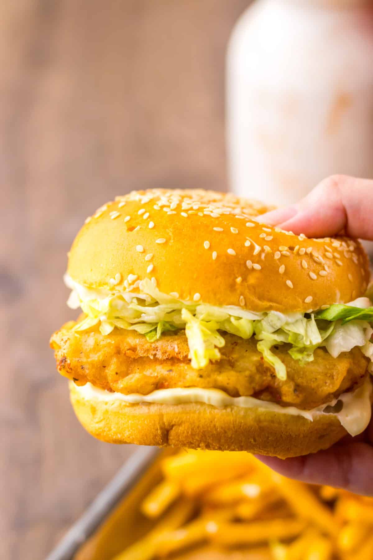 Hand holding a freshly assembled copycat McDonald’s McChicken sandwich.
