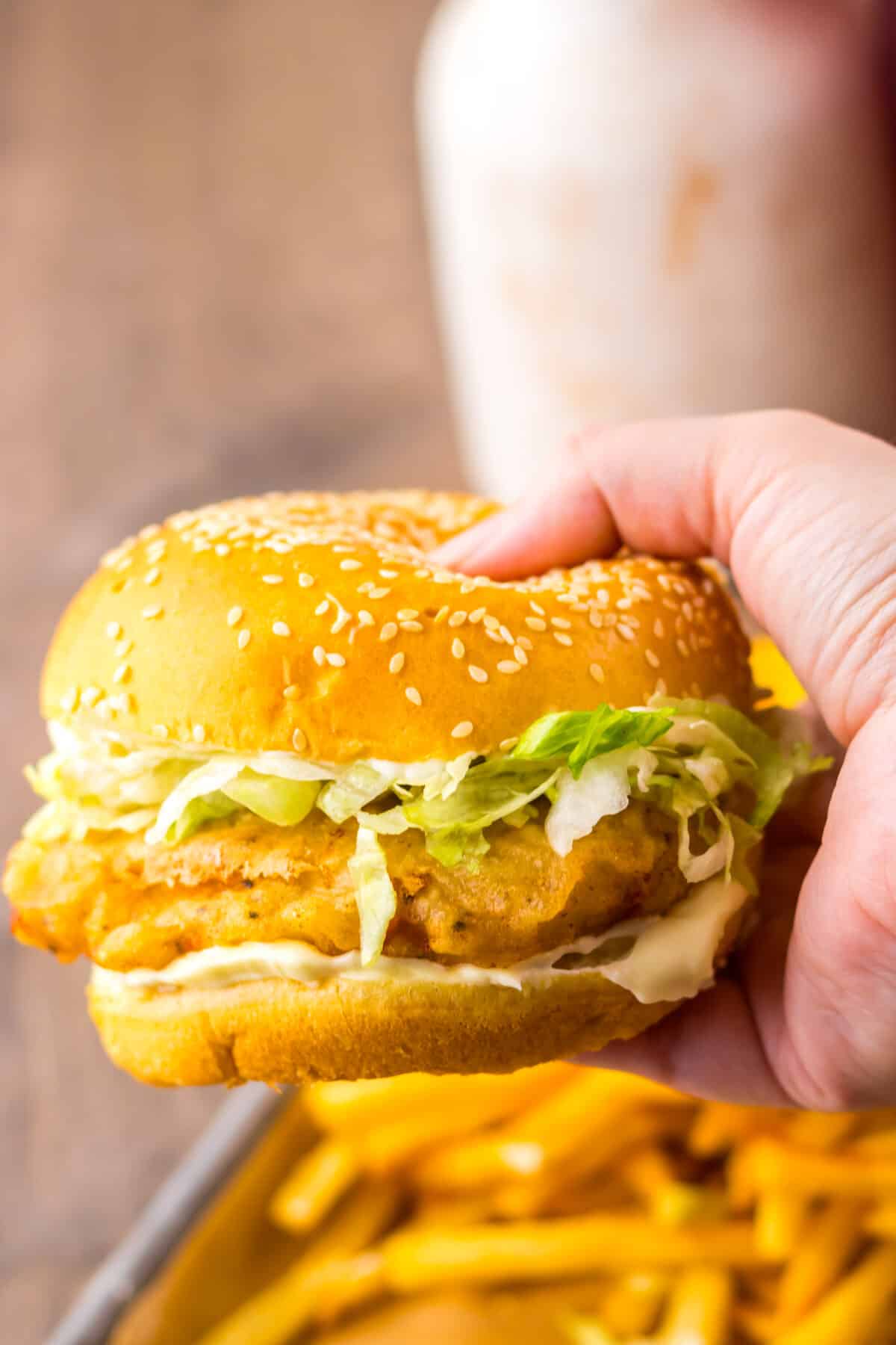 Hand holding a freshly assembled copycat McDonald’s McChicken sandwich.