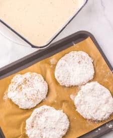 Chicken patties shaped and placed on a parchment-lined baking sheet.