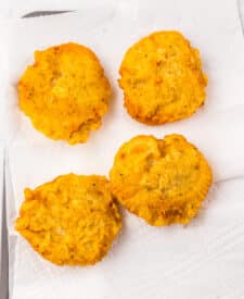 Breaded chicken patties arranged on a baking sheet after cooking.