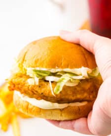 Hand holding a freshly assembled copycat McDonald’s McChicken sandwich.